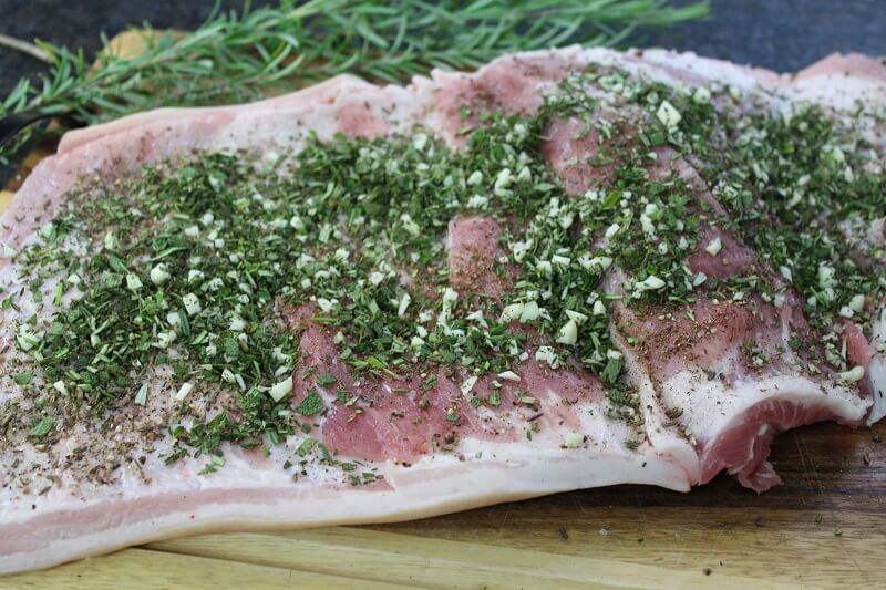Roher Schweinebauch mit kraeutern und gewuerzen