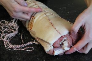 Rollbraten binden schlinge &uuml;ber Fleisch f&uuml;hren - die frau am grill