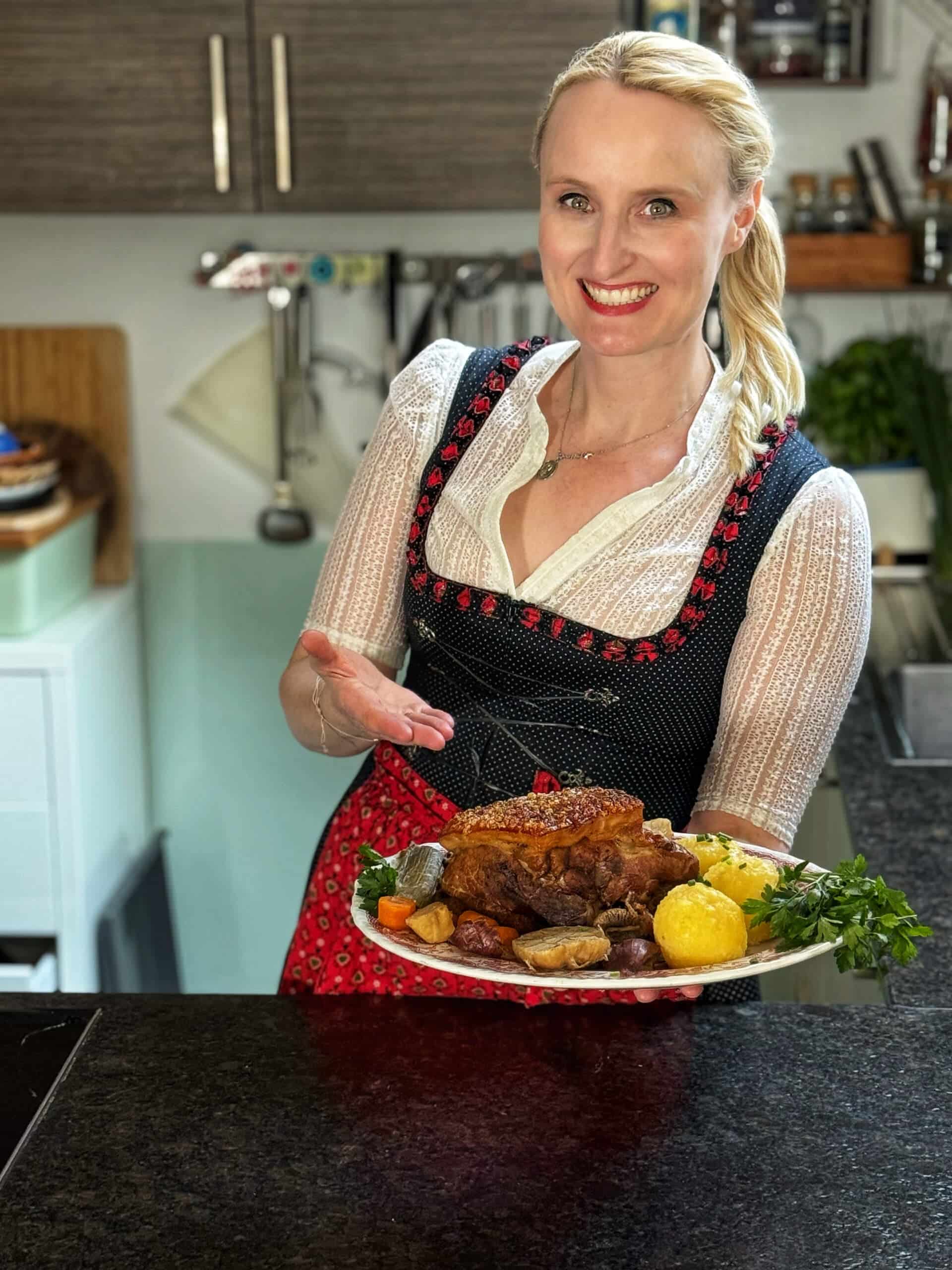 Anja, die Frau am Grill, präsentiert einen knusprigen Schweinebauch