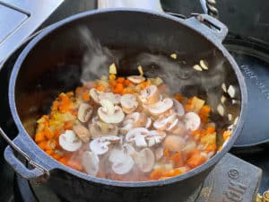 champignonscheiben zu karotten und ziebeln in topf geben