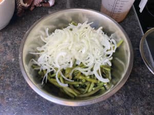 die zwiebeln auf die bohnen in die salatschuessel geben