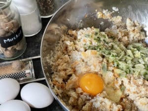 ei, petersilie und zwiebeln zum eingeweichten serviettenknoedel teig geben