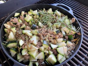 einen zweig rosmarin in die zucchini pfanne einlegen