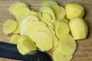 ganze geschaelte kartoffeln in duenne scheiben schneiden