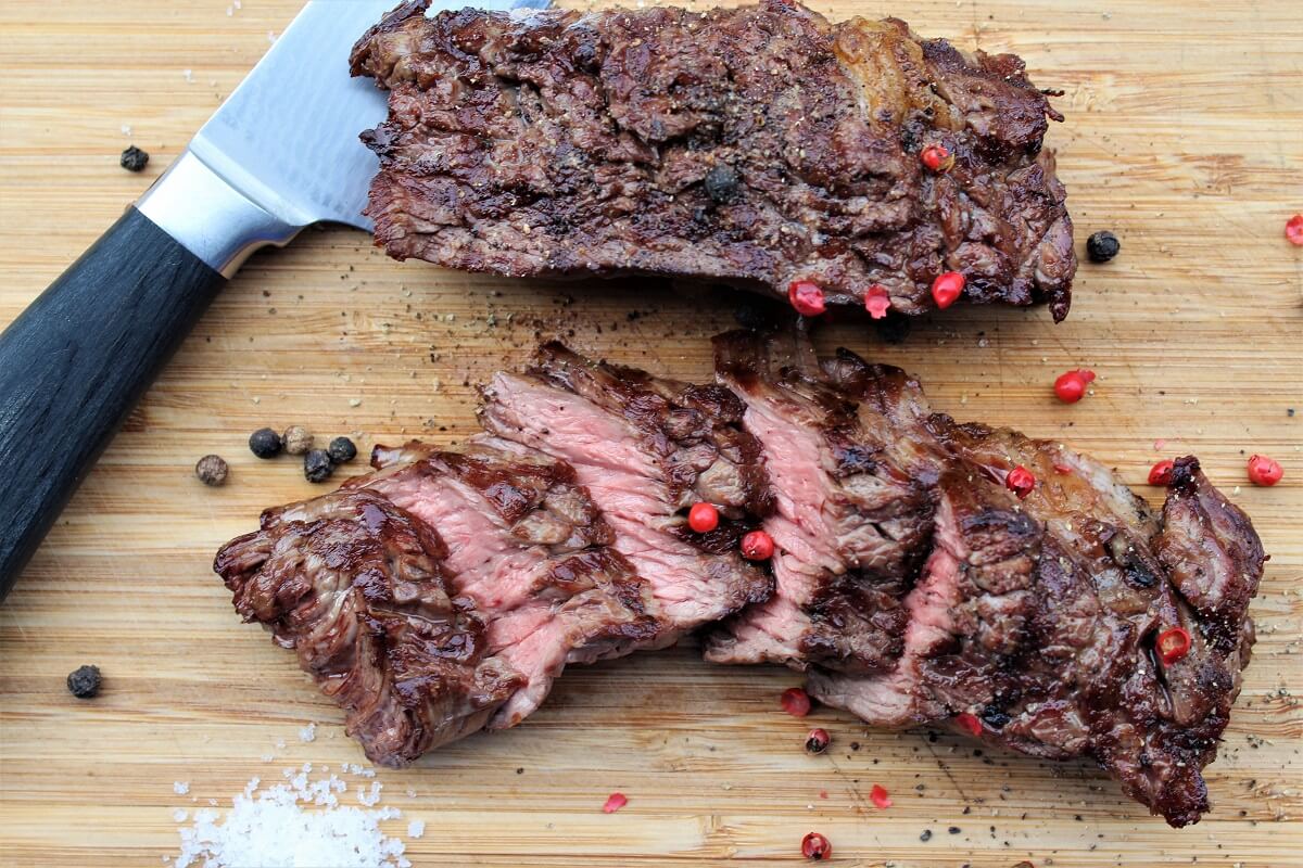 gegrilltes flap steak - flap meat auf brett - die frau am grill