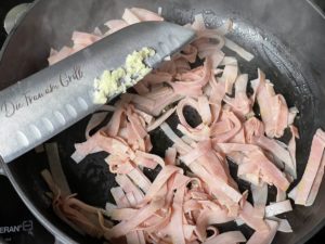 gehackten knoblauch zum kochschinken in die pfanne geben