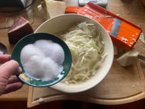 gehobeltes weisskraut in schuessel mit salz und zucker beizen