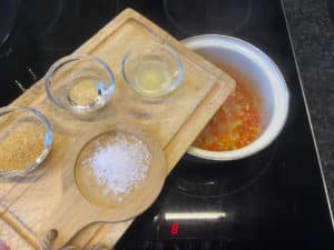 gekochte chilis fuer sambal oelek mit limette, essig, salz und zucker wuerzen