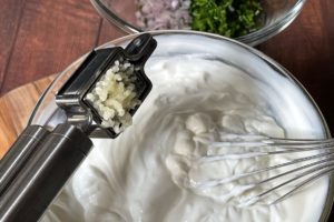 gepressten knoblauch in kraeuterquark geben