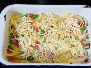 geriebenen kaese ueber nudelauflauf streuen