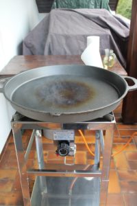 gusspfanne raucht beim einbrennen - die frau am grill