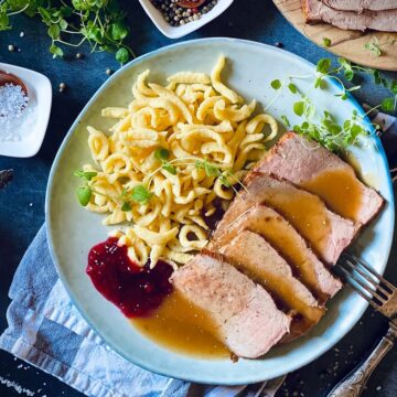 aufgeschnittener Kalbsbraten liegt auf Teller neben Sp&auml;tzle.