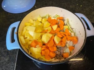 kartoffeln und karotten in den bauerntopf geben