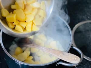 kartoffeln zu angeduensteten zwiebeln in topf geben