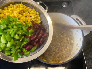 kidneybohnen, mais und paprika ins chili con carne geben
