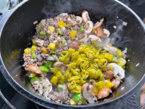 klein geschnittene peperoni fuer die pizzasuppe in den dutch oven geben