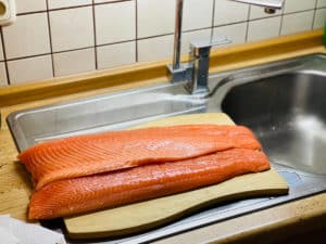 lachshaelfte gewaschen und trocken getupft auf kuechenbrett