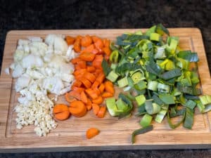 lauch, karotten, zwieblen, sellerie und knoblauch klein geschnitten auf brett