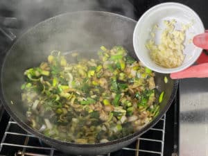 lauch, zwiebeln und knoblauch in pfanne anduensten