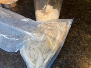 mehlierte rohe zwiebeln in plastiktuete