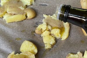 olivenoel ueber zerstampfte kartoffeln geben