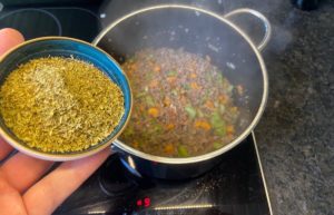 oregano zur bolognese sauce in den topf geben