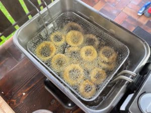 panierte zwiebelringe in fritteuse frittieren