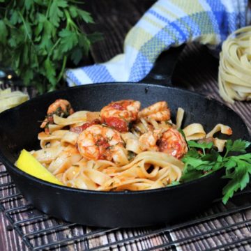 nudeln in pfanne mit garnelen und tomatensosse