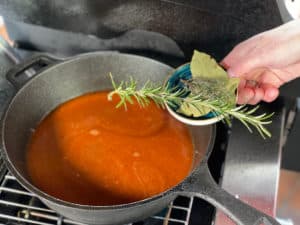 pfeffersauce mit rosmarin, thymian, lorbeerblaetter und gruenem pfeffer wuerzen