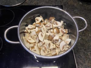 pilze zu speck und zwiebeln in topf zum duensten geben