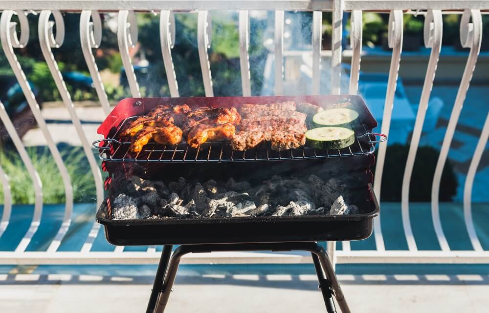 rauchender kohlegrill auf balkon