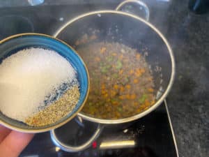 salz und pfeffer fuer die spaghetti bolognese sauce in den topf geben