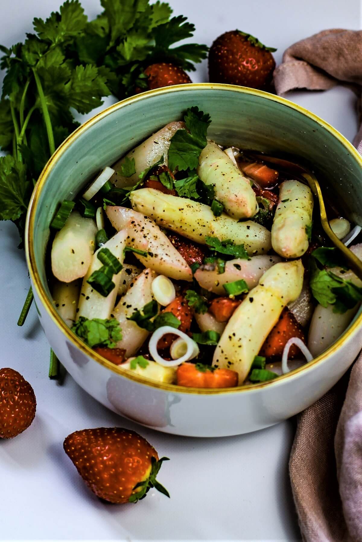 spargelsalat in einer schuessel mit erdbeeren