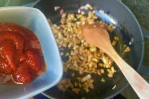 tomatenmark fuer shakshuka in pfanne geben