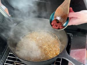 tomatenmark in fett in pfanne anroesten