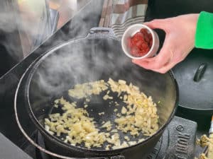 tomatenmark zu angebratenen zwiebeln in den topf geben
