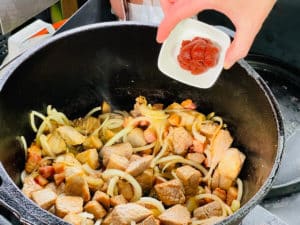 tomatenmark zum angebratenem fleisch und zwiebeln geben