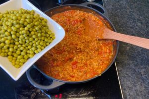vorgekochte gruene erbsen in die djuvec reis pfanne geben und einmal erhitzen