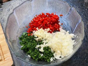 zwiebel, knoblauch, petersilie und paprika klein geschnitten in schuessel