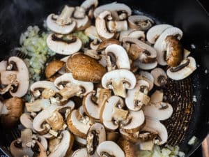 zwiebeln, knoblauch und champignons in einer pfanne anduensten