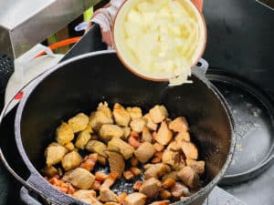 zwiebeln zum angebratenen schweinegulasch geben