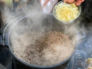 zwiebelwuerfel und knoblauch zu angebratenem hackfleisch in topf geben