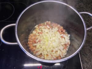 zwiebelwuerfel zum angebratenen speck in den topf geben